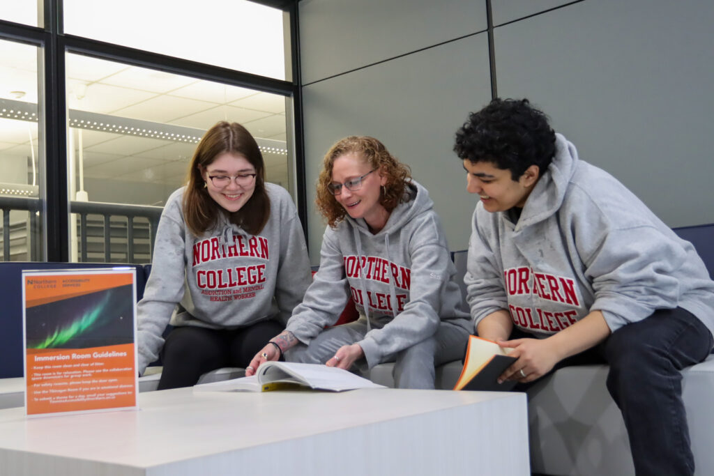 group of students looking at textbook