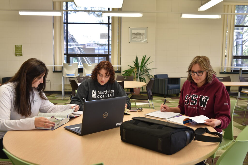 Three students studying in library