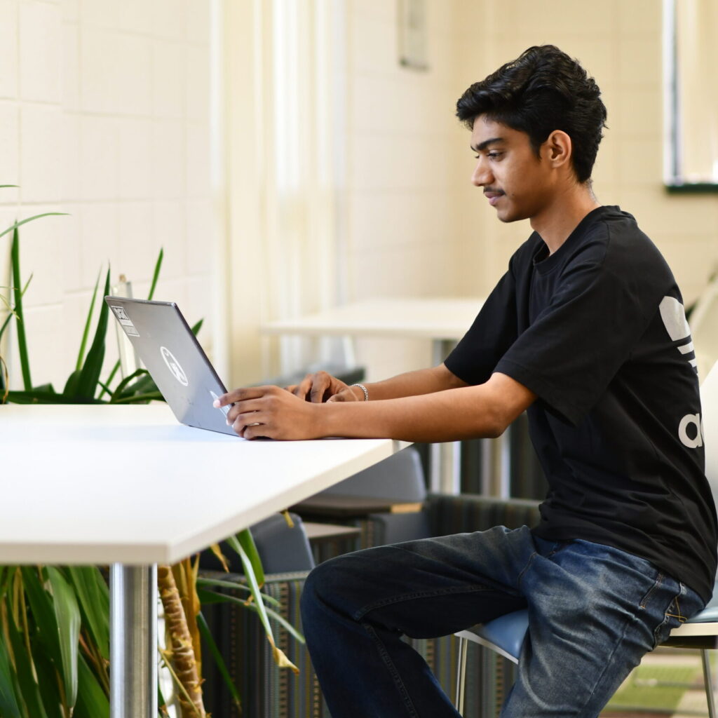 Business student at laptop in library