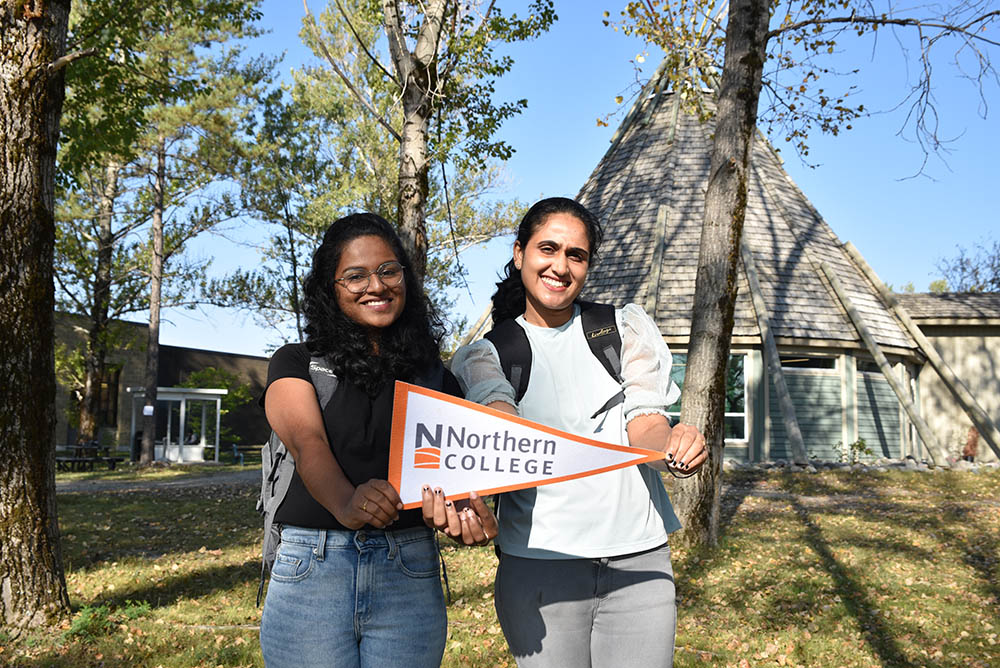 Northern College students holding a Northern College flag.