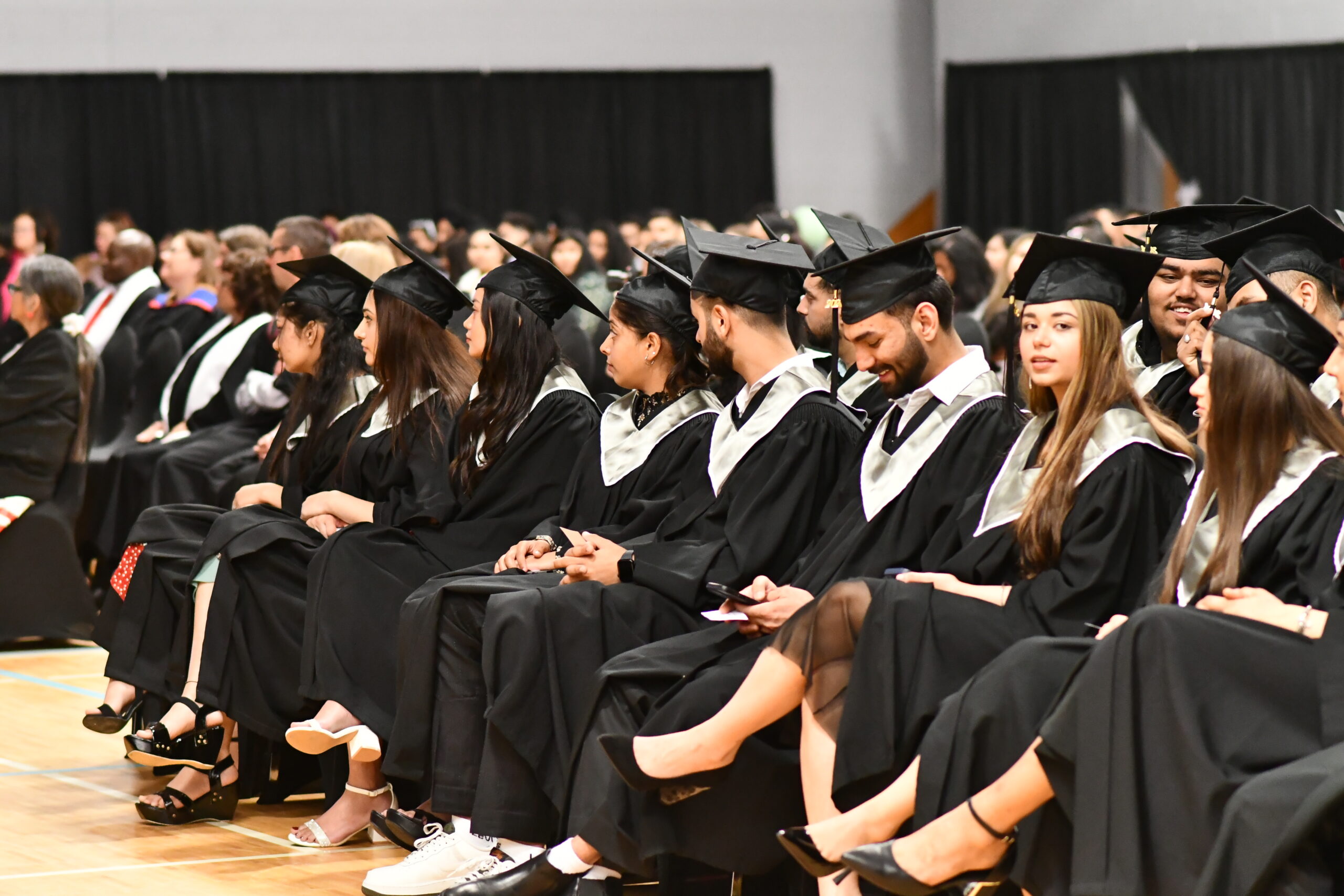 Northern College graduating students sitting in gowns at graduation ceremony at timmins campus